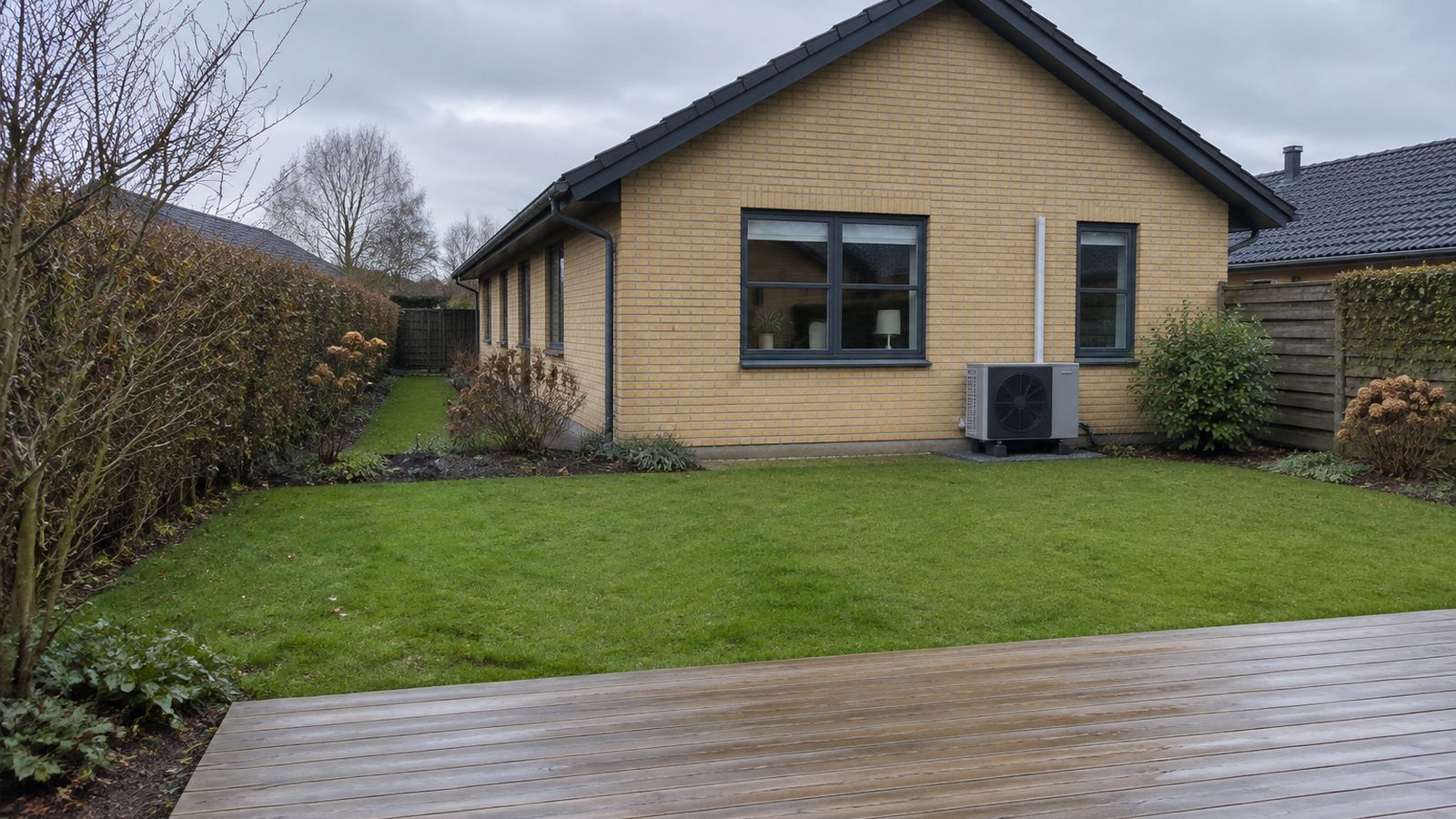 Ny fliseterrasse i aftenlys bag en dansk bolig